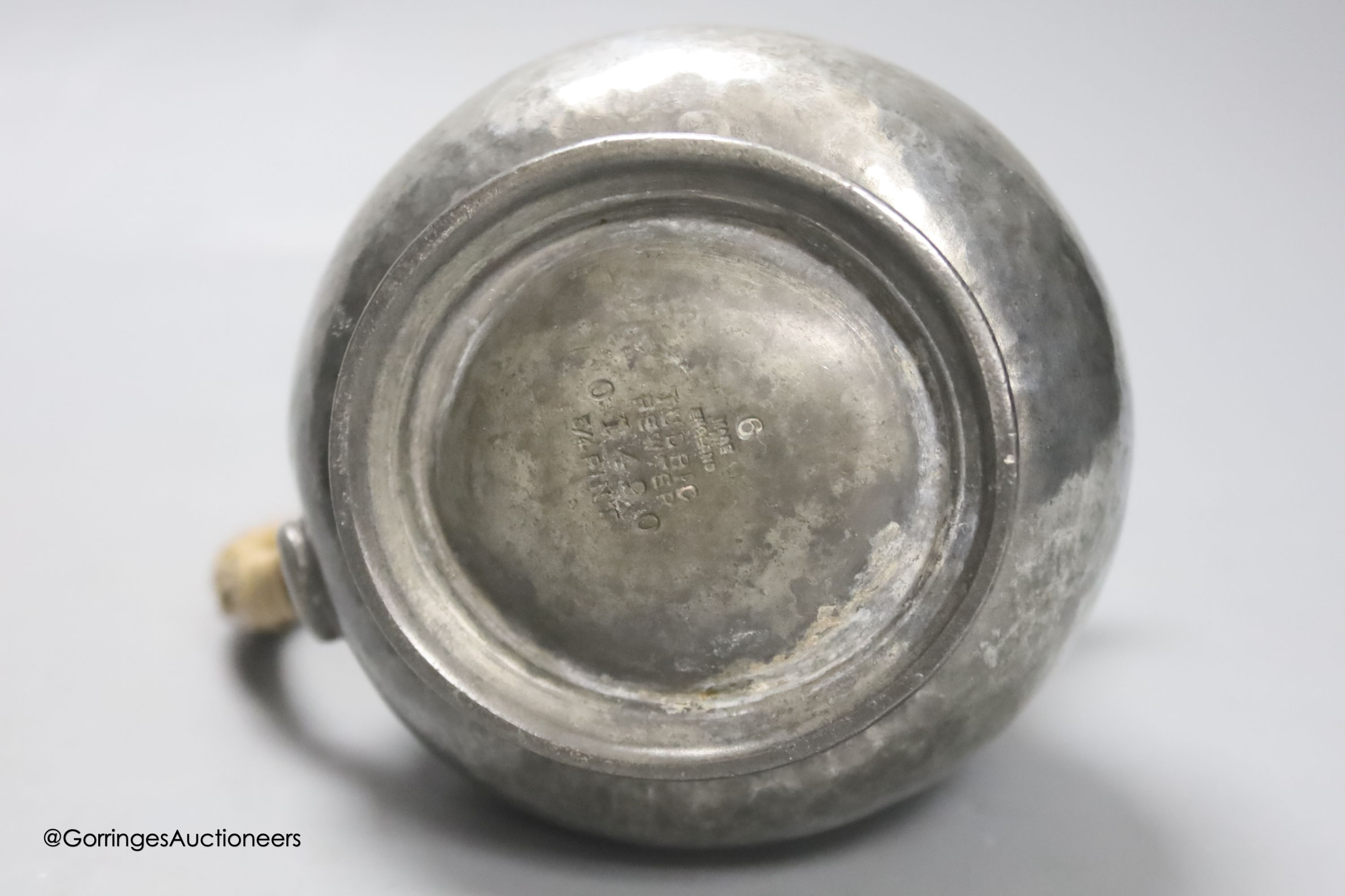 A Liberty & Co Tudric pewter pin dish, a Tudric covered jug and a pewter candleholder